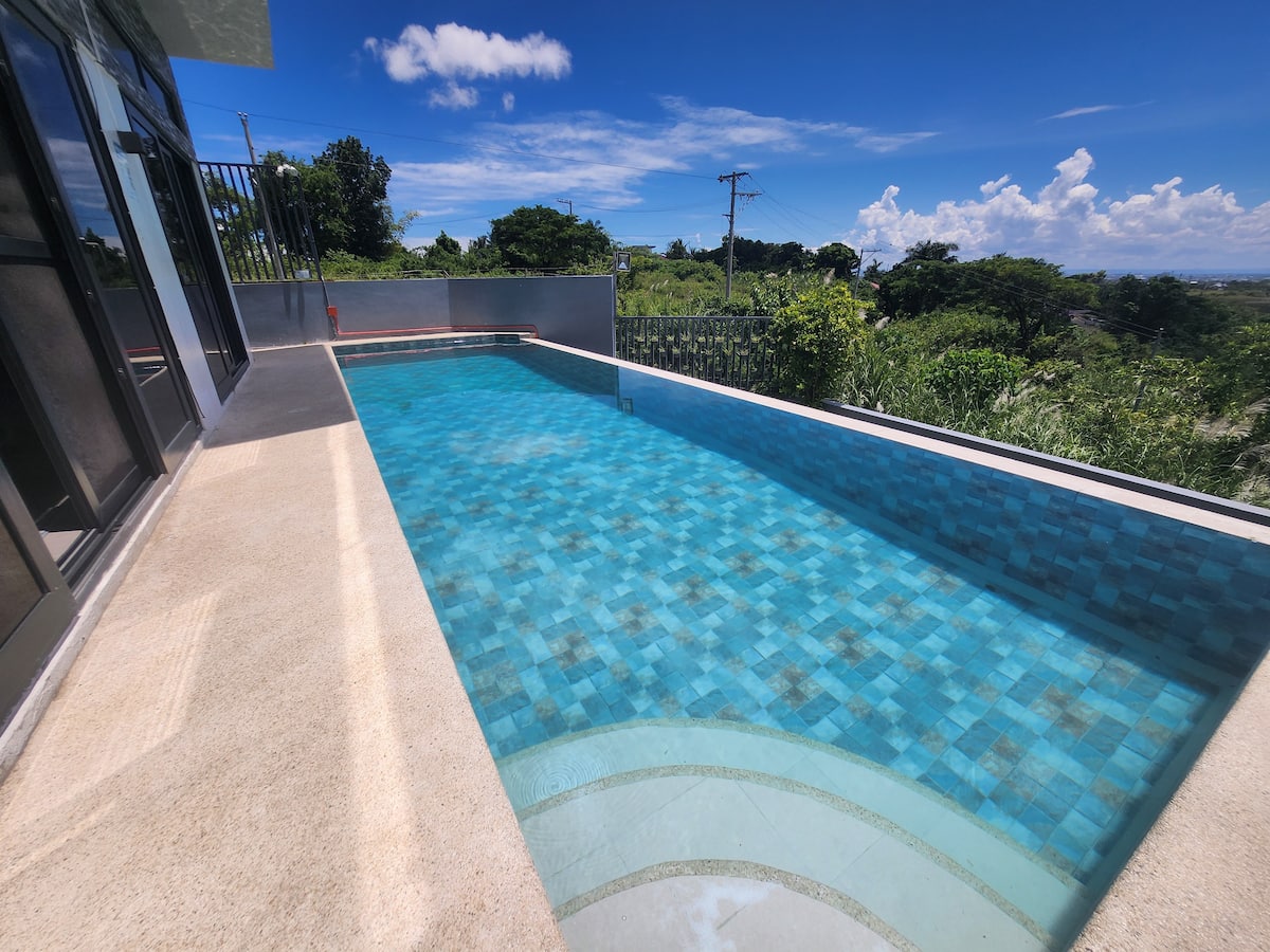 Infinity pool at Villa Tuscany overlooking the green hills and Cebu skyline